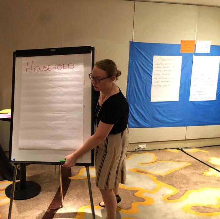 Erika holding a poster board in a conference room while she facilitates a discussion around integrating women in vector control in Bali, Indonesia in 2019